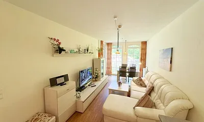 Wohnbereich mit gemütlicher Couch, Leselampe, Smart-TV, DVD-Player und Radio mit CD