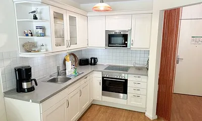 Küchenzeile mit Mikrowelle, Backofen, Ceranfeld, Spülmaschine, Kühlschrank mit Gefrierfach, Kaffeemaschine und praktischen Helfern