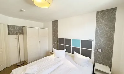 Schlafzimmer mit Boxspringbett (1,80 m x 2,00 m), Nachttischkonsolen, Kleiderschrank und LED-TV