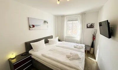 Schlafzimmer mit komfortablen Boxspringbett (1,80 m x 2,00 m), hochwertige durchgehende Matratze, Nachttischkonsolen, 2-trg. Kleiderschrank und TV