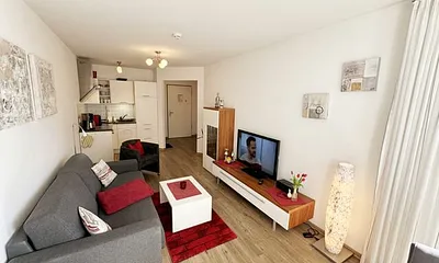 Wohnbereich mit gemütlicher Couch, heller Anrichte, Flachbild TV, DVD-Player und eine CD-Musikanlage