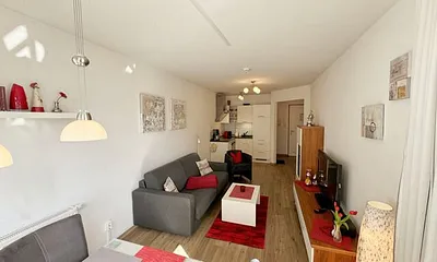 Wohnbereich mit gemütlicher Couch, heller Anrichte, Flachbild TV, DVD-Player und eine CD-Musikanlage