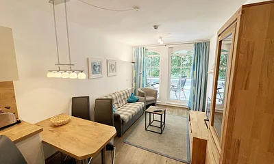 Wohnbereich mit gemütlicher Couch (Aufbettung für die 3. Person 1,30 m x 1,95 m), Sessel, Couchtisch, Leselampe, kleine Anrichte mit LCD-TV sowie ein Radio mit CD 