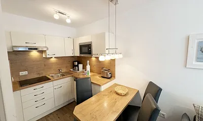 integrierte Küchenzeile mit Mikrowelle und Grillfunktion, Ceranfeld, Abzugshaube, Spülmaschine, Kühlschrank mit Gefrierfach, Kaffeemaschine und anderen praktischen Helfern