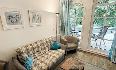 Wohnbereich mit gemütlicher Couch (Aufbettung für die 3. Person 1,30 m x 1,95 m), Sessel, Couchtisch, Leselampe, kleine Anrichte mit LCD-TV sowie ein Radio mit CD 