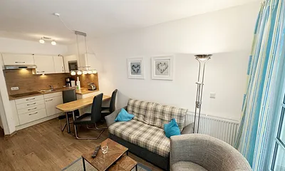 Wohnbereich mit gemütlicher Couch (Aufbettung für die 3. Person 1,30 m x 1,95 m), Sessel, Couchtisch, Leselampe, kleine Anrichte mit LCD-TV sowie ein Radio mit CD 