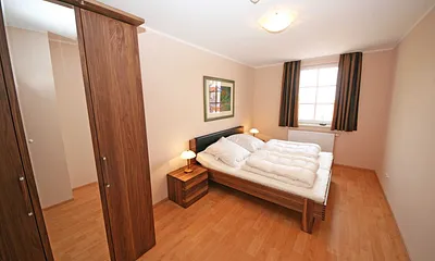 Schlafzimmer mit komfortablen Doppelbett (1,80 m x 2,00 m) und einem Kleiderschrank