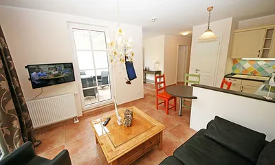 liebevoll eingerichteter Wohnbereich mit Couch, Flachbild-TV sowie Radio mit CD-Player