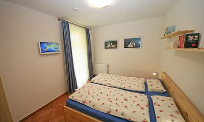 Schlafzimmer mit Doppelbett (2 x 0,90 m x 2,00 m) , geräumiger Kleiderschrank und Nachttischkästen sowie ein kleiner Flachbild TV