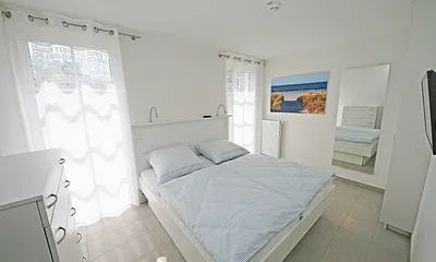 Schlafzimmer mit Doppelbett (1,80 m x 2,00 m), Flachbild TV und einem Kleiderschrank