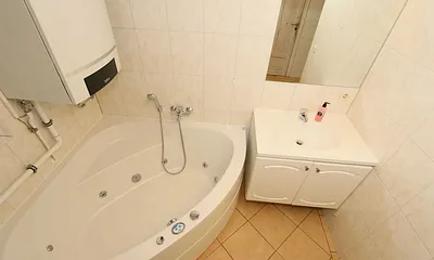 Badezimmer mit ebenerdiger Dusche, Waschplatz, WC, Fön, Kosmetikspiegel, Waschmaschine, Sauna und Badewanne mit Whirlpool