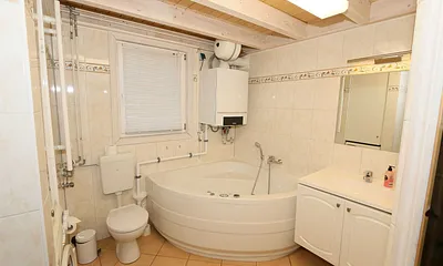 Badezimmer mit ebenerdiger Dusche, Waschplatz, WC, Fön, Kosmetikspiegel, Waschmaschine, Sauna und Badewanne mit Whirlpool