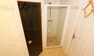 Badezimmer mit ebenerdiger Dusche, Waschplatz, WC, Fön, Kosmetikspiegel, Waschmaschine, Sauna und Badewanne mit Whirlpool