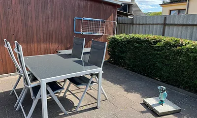 Grosse Terrasse mit Tisch und mobilen Sonnenschirm