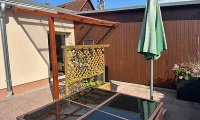 Grosse Terrasse mit Tisch und mobilen Sonnenschirm