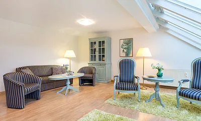 Die Fenster sind mit Plissees ausgestattet. Das Wohnzimmer schaut nach Nordosten auf die Ostsee. Die Couch hat keine Schlaffunktion.