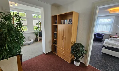 Der Flur mit Blick in ein Schlafzimmer und Veranda. Im Schrank befindet sich eine kleine Bibliothek, Kinder -DVD's und einige Spiele 