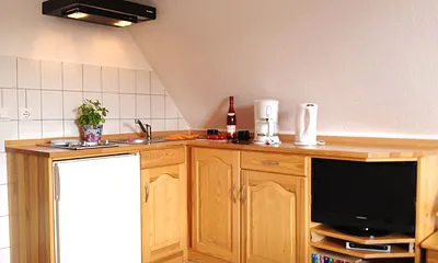 Küchenzeile (2-Plattenherd, Wasserkocher, Kaffeemaschine, Toaster) mit Entertainementbereich (Flachbild-TV, Bücherecke)