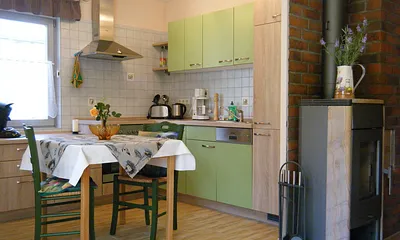 Offene Küche mit Esstisch und Kamin zum Wohnbereich gerichtet