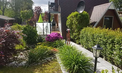 Das BIld zeigt die Vorderansicht des Finnhauses mit Weg und Parkplatz direckt vor dem Haus