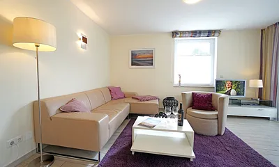 Wohnzimmer mit komfortabler Sitzgarnitur und Fernseher