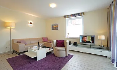 Wohnzimmer mit komfortabler Sitzgarnitur und Fernseher