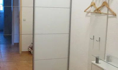 Ankleidezimmer mit Schwebtürenschrank und Garderobe auch als Abstellraum nutzbar