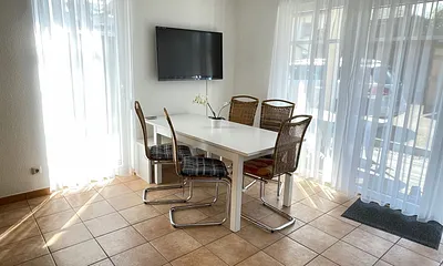 Wohnzimmer mit Esstisch und Fernseher