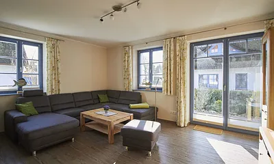 Das Wohnzimmer ist hell und lichtdurchflutet. Die große bequeme Kuschelcouch sorgt für Entspannung und Bequemlichkeit.