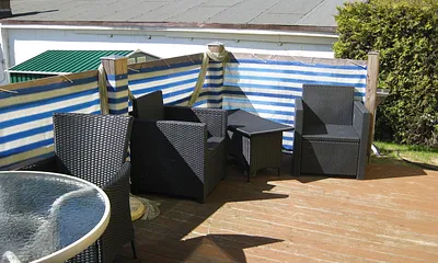 auf der Terrasse stehen Gartenmöbel und ein Grill für Sie bereit