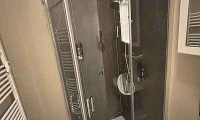 Blick in das Bad mit WC, Regendusche, WC, Fön