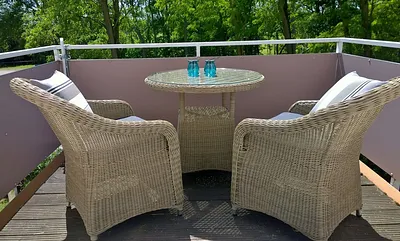 Balkon mit bequemen Sesseln und Esstisch