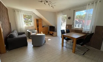 Helles gemütliches Wohnzimmer mit Smart-TV, Essbereich und Balkon