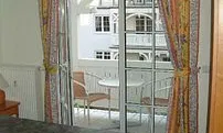 Schlafzimmer mit bequemem Doppelbett und Balkon