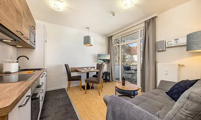 Das Wohnzimmer mit TV, Stereo-Anlage mit CD-Player und Austritt zum möblierten Balkon.