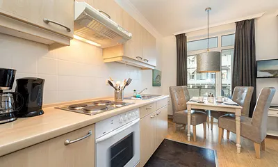 Hier der Blick von der Küchenzeile (mit 4-Platten-Herd, Backofen, Kühlschrank mit Gefrierfach, Kaffeemaschine, Wasserkocher und Toaster) zum Eßbereich.