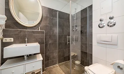 Das moderne Bad hat Echtglasdusche, WC und Fön. 