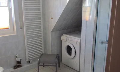 Badezimmer mit großer Dusche und Waschmaschine