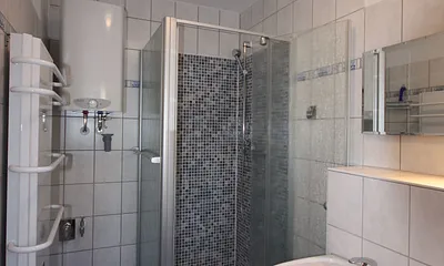 Bad mit tiefer Mosaikdusche und Handtuchwärmer