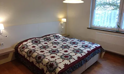 Schlafzimmer mit Doppelbett und Kleiderschrank