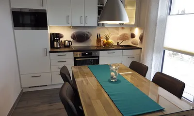 Voll ausgestattete Küche mit Esstisch