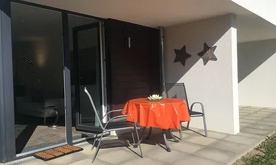 Die Terrasse mit Möbeln und Sonnenschirm