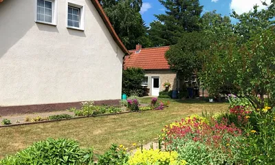 Blick auf den Giebel mit Wiese und Blumen