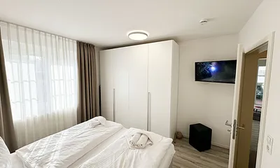 Schlafzimmer mit Kleiderschrank und TV