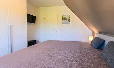 zweites Schlafzimmer mit Kleiderschrank und TV