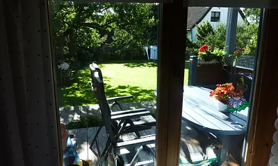 Blick aus dem Wohnzimmer auf die Terrasse und den Garten