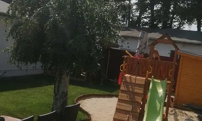 Garten mit Spielplatz, Sitzecke und ganz rechts zu sehen ist die Außensauna