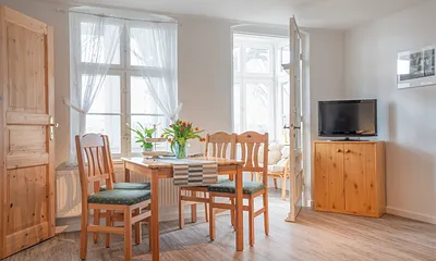 Wohnzimmer mit Esstisch und Flachbildfernseher