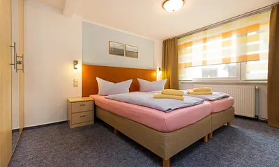 Das Schlafzimmer hat Doppelbett, Kleiderschrank und Verdunkelungsgardinen.