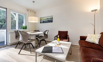 Das Wohnzimmer mit Eßbereich und Austritt zum Balkon.